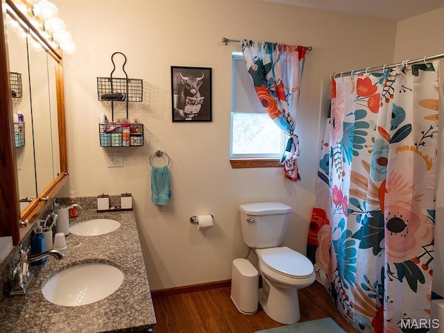 full bathroom featuring wood finished floors, toilet, baseboards, double vanity, and a shower with curtain