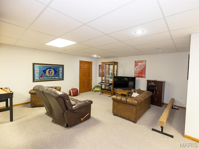 living area featuring carpet, a drop ceiling, and baseboards