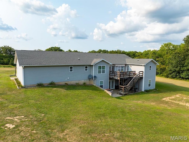 back of property featuring a deck and a lawn