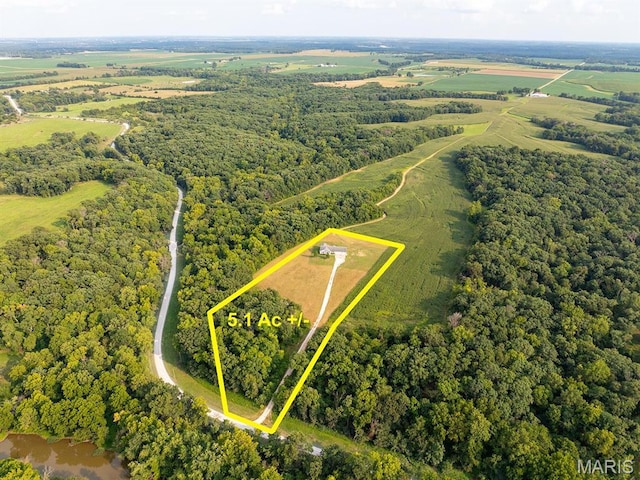 aerial view of property and surrounding area featuring property boundaries highlighted and a forest