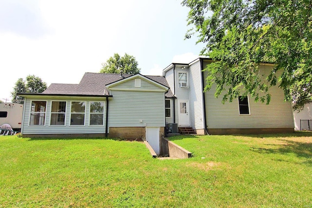 rear view of house with a lawn, central air condition unit, and entry steps
