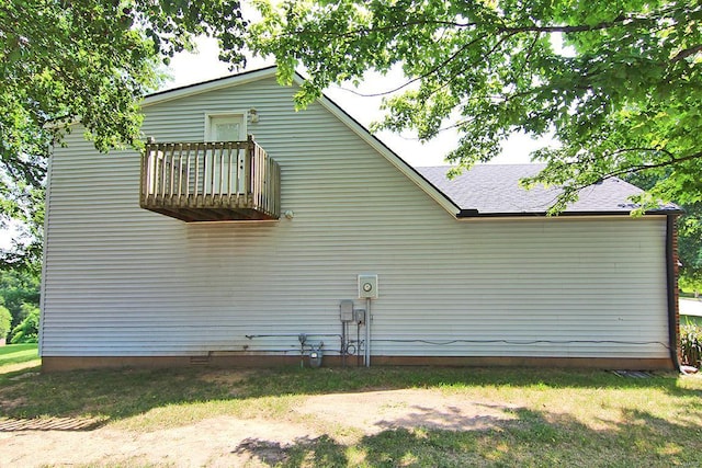 view of property exterior featuring a balcony and a shingled roof