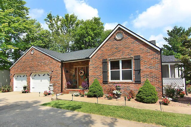 view of front of property featuring brick siding, driveway, an attached garage, and roof with shingles