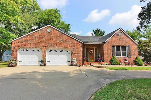 view of front of property featuring driveway, brick siding, and an attached garage