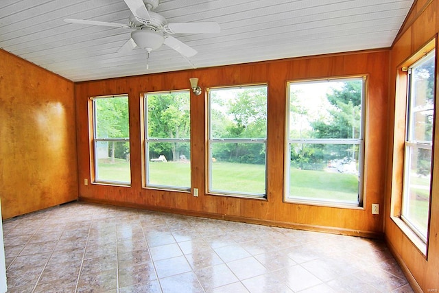 unfurnished sunroom featuring wood walls and tile patterned flooring