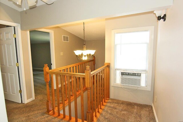 stairway featuring carpet floors, a chandelier, cooling unit, and a ceiling fan