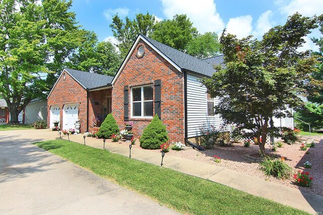 view of front facade with brick siding, a garage, driveway, and a shingled roof
