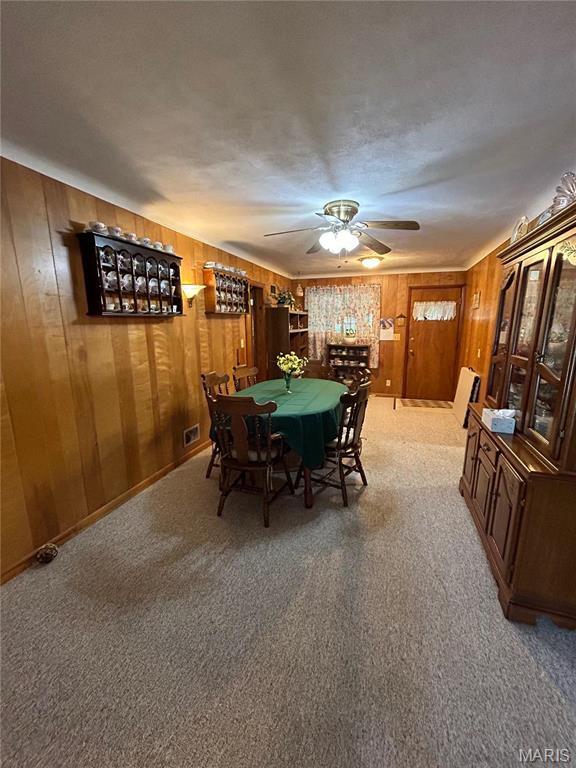 102 W Center St, Salem, MO 65560 - dining room with carpet flooring, ceiling fan, and wood walls