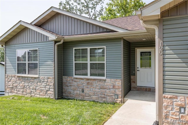 129 Jared St, Waynesville, MO 65583 - doorway to property featuring stone siding, board and batten siding, roof with shingles, and a yard