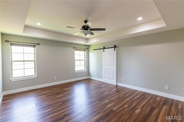 129 Jared St, Waynesville, MO 65583 - unfurnished room featuring a raised ceiling, dark wood finished floors, a barn door, a ceiling fan, and recessed lighting