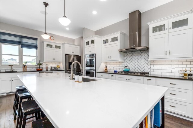 128 Jared St, Waynesville, MO 65583 - kitchen with wall chimney range hood, appliances with stainless steel finishes, backsplash, a kitchen breakfast bar, and recessed lighting