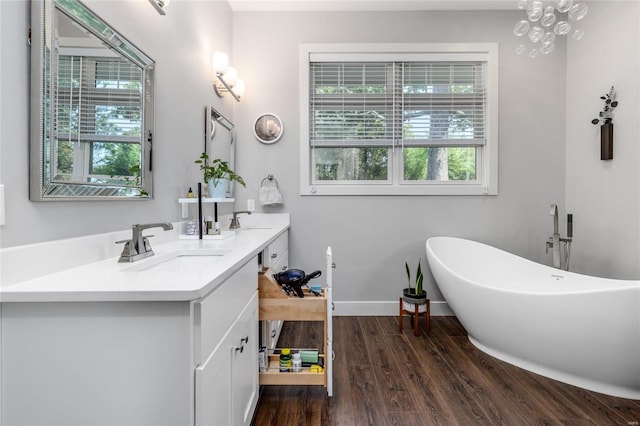 128 Jared St, Waynesville, MO 65583 - bathroom with wood finished floors, a freestanding tub, double vanity, and baseboards