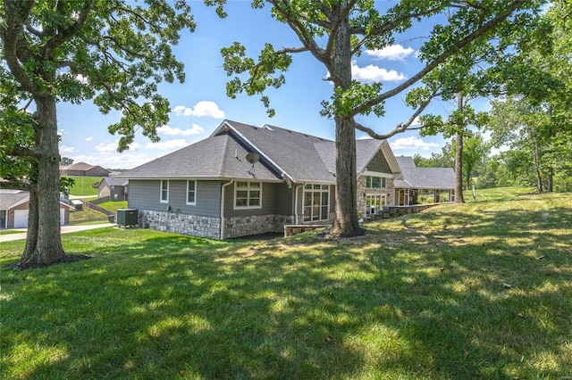 128 Jared St, Waynesville, MO 65583 - back of house with central AC, stone siding, a lawn, and roof with shingles