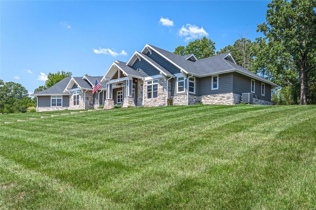 128 Jared St, Waynesville, MO 65583 - craftsman-style home with stone siding, central AC, a front yard, and roof with shingles