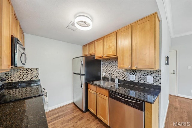 5673 Waterman Blvd Unit 31, Saint Louis, MO 63112 - kitchen with stainless steel appliances, a sink, light wood-type flooring, backsplash, and dark stone countertops