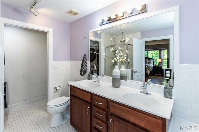 1010 Winter Lake Dr, Fenton, MO 63026 - full bath featuring a stall shower, double vanity, tile patterned flooring, wainscoting, and toilet