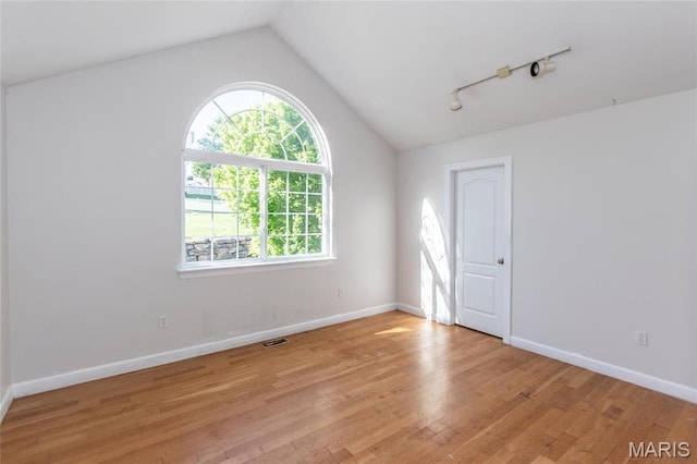 1010 Winter Lake Dr, Fenton, MO 63026 - empty room with vaulted ceiling, light wood-style floors, baseboards, and rail lighting