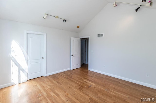 1010 Winter Lake Dr, Fenton, MO 63026 - unfurnished bedroom with baseboards, light wood-style floors, high vaulted ceiling, and track lighting