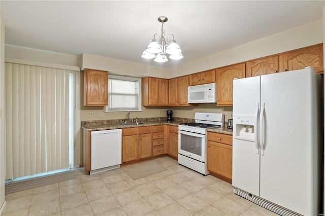 kitchen featuring white appliances, a sink, a chandelier, pendant lighting, and light floors