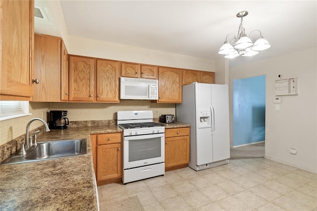 kitchen featuring white appliances, a sink, a chandelier, hanging light fixtures, and backsplash