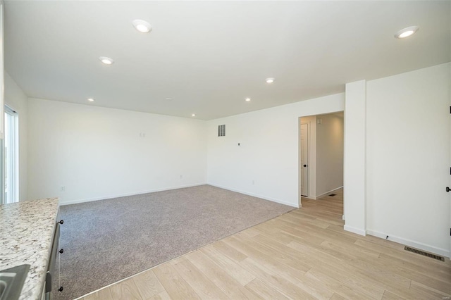 unfurnished room with light wood-style flooring, recessed lighting, and baseboards