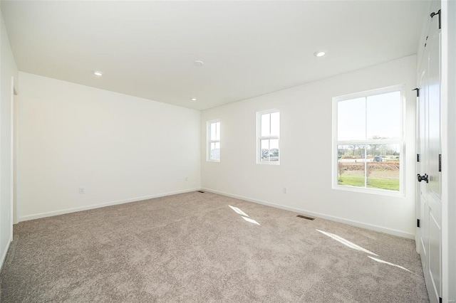 empty room with light colored carpet, baseboards, and recessed lighting
