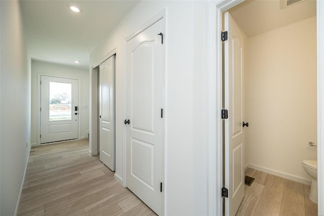 hallway with light wood-type flooring, recessed lighting, and baseboards