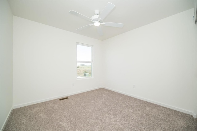 carpeted spare room with baseboards and ceiling fan