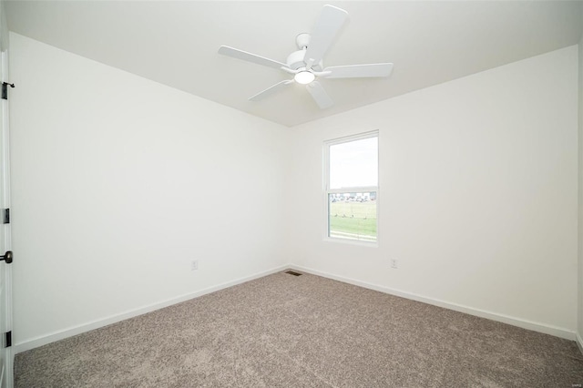 carpeted spare room with ceiling fan and baseboards