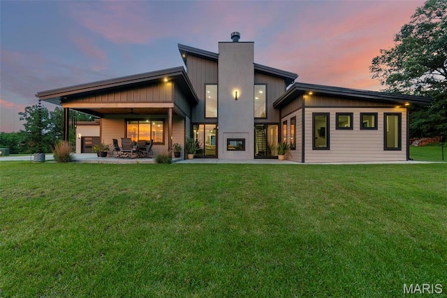 173 Tate Rdg, Cape Girardeau, MO 63701 - back of house at dusk with a chimney, a patio, and a yard
