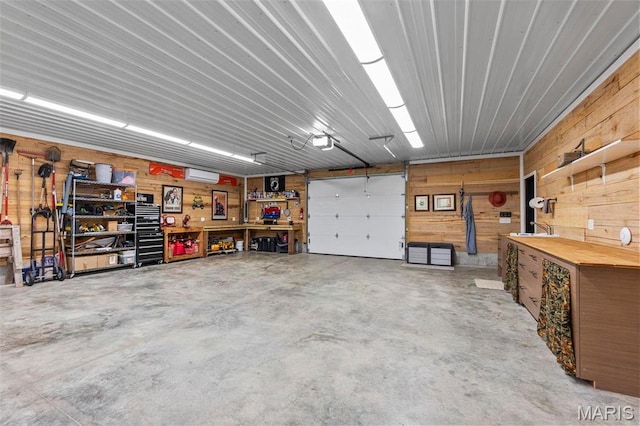 173 Tate Rdg, Cape Girardeau, MO 63701 - garage featuring a workshop area, wood walls, a garage door opener, and a wall unit AC