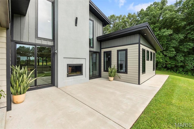 173 Tate Rdg, Cape Girardeau, MO 63701 - rear view of property with a patio area, a lawn, and board and batten siding