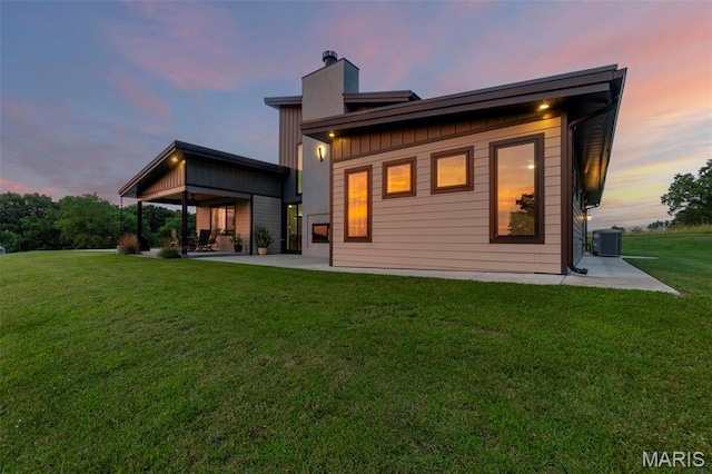 173 Tate Rdg, Cape Girardeau, MO 63701 - back of property with a patio area, a chimney, a yard, and board and batten siding