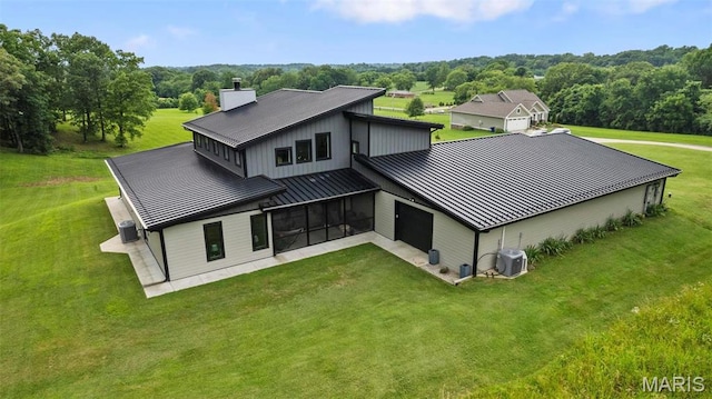 173 Tate Rdg, Cape Girardeau, MO 63701 - back of property featuring a standing seam roof, a metal roof, a chimney, an attached garage, and a lawn