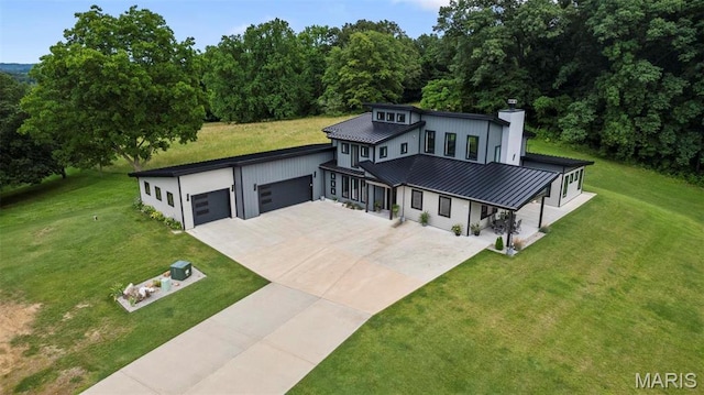 173 Tate Rdg, Cape Girardeau, MO 63701 - view of front facade featuring concrete driveway, a standing seam roof, a garage, a chimney, and a front lawn