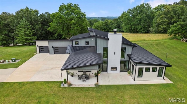 173 Tate Rdg, Cape Girardeau, MO 63701 - back of house with a standing seam roof, an outbuilding, a lawn, a metal roof, and a chimney