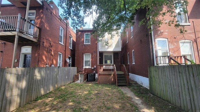 3253 Texas Ave, Saint Louis, MO 63118 - back of house with fence, central AC unit, and brick siding
