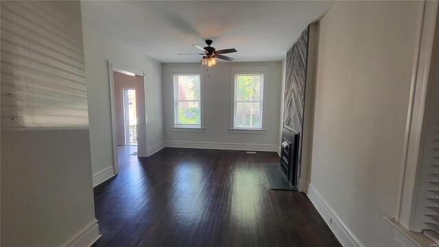 3253 Texas Ave, Saint Louis, MO 63118 - unfurnished living room featuring baseboards, dark wood-type flooring, a ceiling fan, and a fireplace with flush hearth