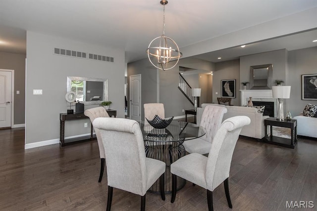 2708 Brook Hill Ln, Saint Charles, MO 63303 - dining space featuring a chandelier, dark wood-style flooring, baseboards, stairs, and a fireplace