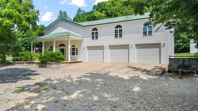 10912 State Highway 77, Chaffee, MO 63740 - view of front of home with concrete driveway, an attached garage, a porch, and metal roof