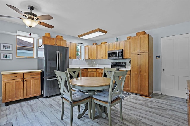 7102 Shadow Ln, Villa Ridge, MO 63089 - kitchen featuring appliances with stainless steel finishes, a sink, healthy amount of natural light, and light wood-style flooring
