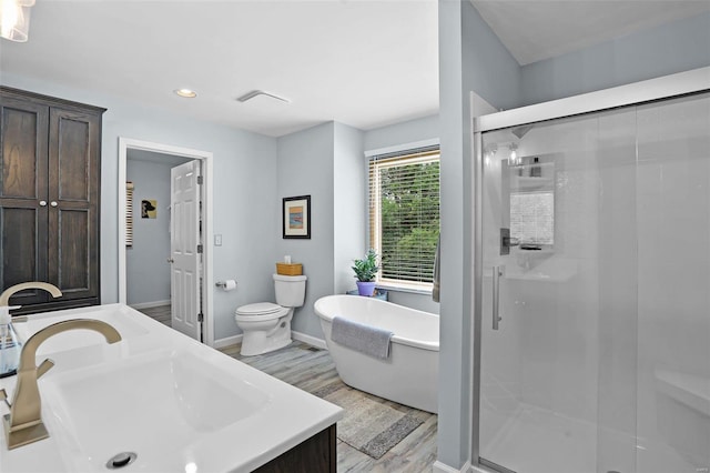 7102 Shadow Ln, Villa Ridge, MO 63089 - full bath featuring a stall shower, a freestanding bath, wood finished floors, baseboards, and recessed lighting