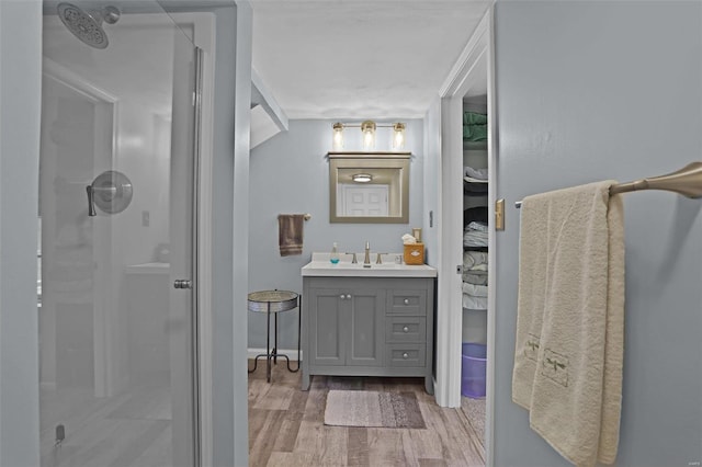 7102 Shadow Ln, Villa Ridge, MO 63089 - bathroom with a shower stall, wood finished floors, vanity, and baseboards