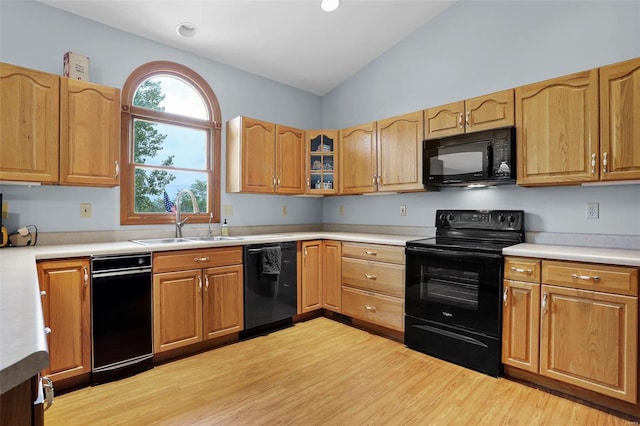 7102 Shadow Ln, Villa Ridge, MO 63089 - kitchen with black appliances, a sink, lofted ceiling, light wood finished floors, and light countertops
