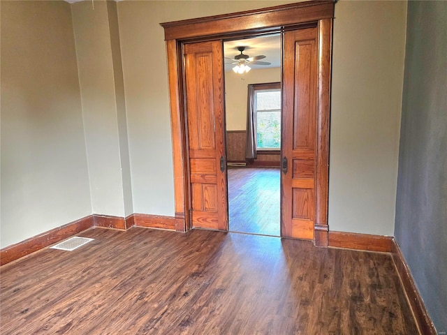 spare room featuring wood finished floors, baseboards, and a ceiling fan