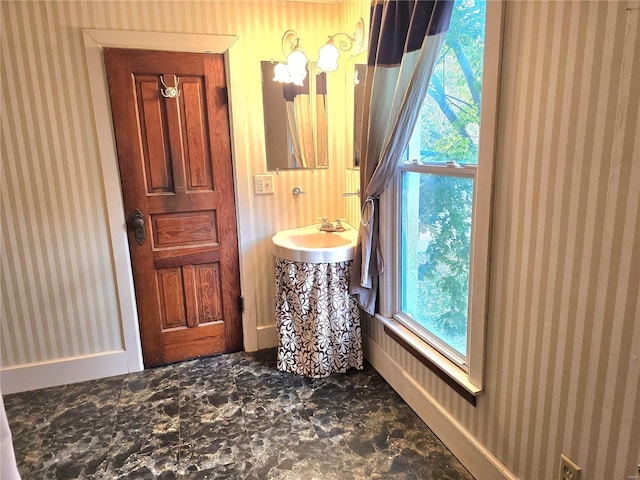 bathroom with a sink and wallpapered walls