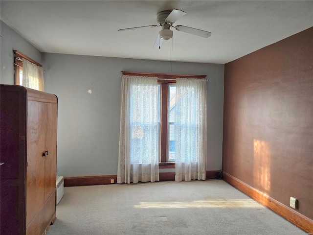 spare room with baseboards, a ceiling fan, and carpet floors