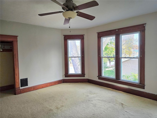 spare room featuring carpet floors, baseboards, and ceiling fan