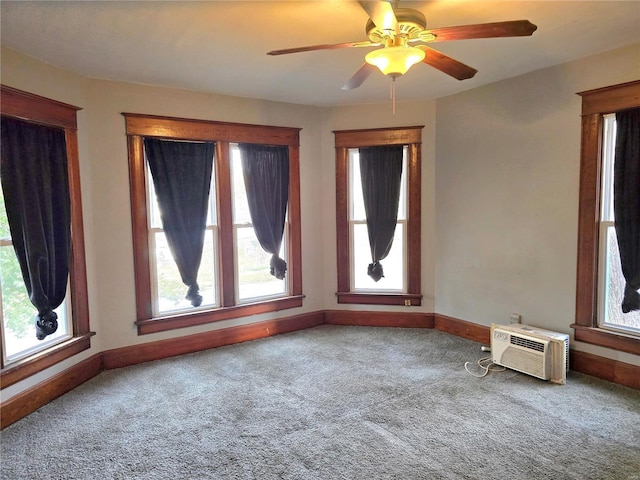 carpeted empty room with healthy amount of natural light, baseboards, a ceiling fan, and a wall mounted air conditioner
