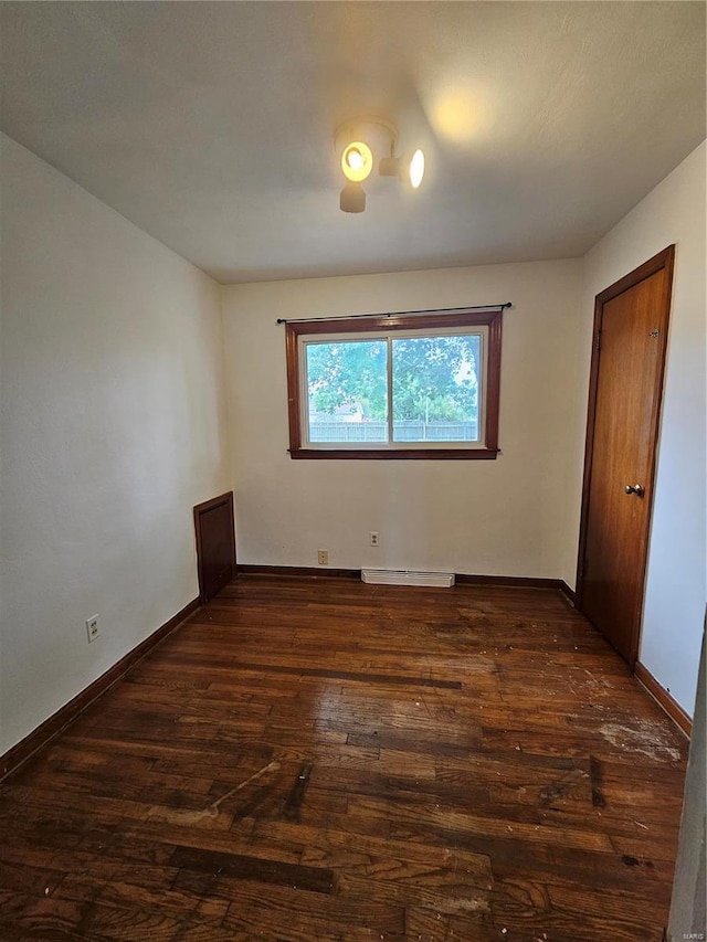 unfurnished bedroom featuring dark wood-style flooring and baseboards